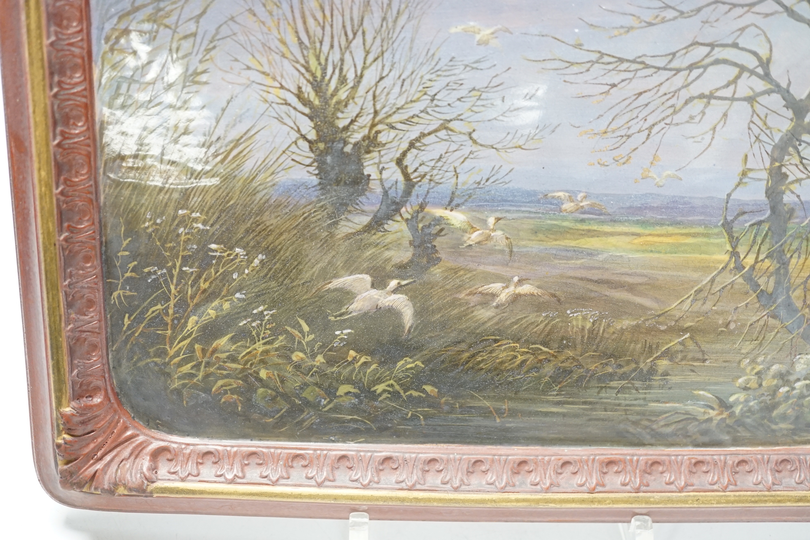 A late 19th century French painted faience plaque of storks in a landscape, 18 x 25cm